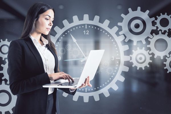 Frau am Laptop mit Zahnrad-Grafiken
